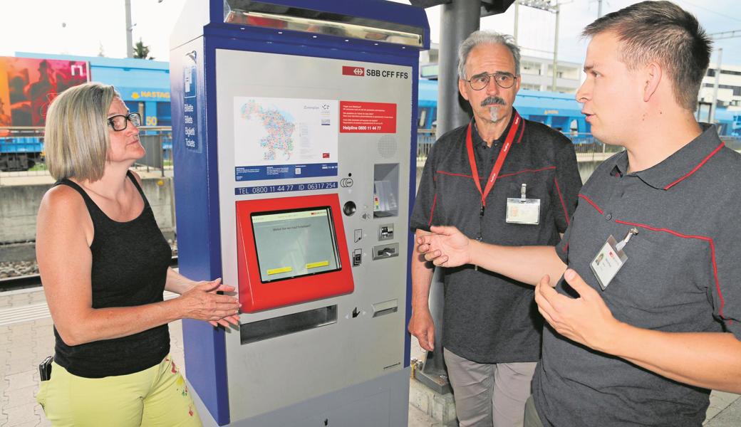 Was machen Bahnhofpaten? Harald Grimme (Mitte) und Marcel Adolf erklären einer Passantin, dass sie bei der Bedienung des Billettautomaten helfen, Reisende beim Ein- und Ausladen von Gepäckstücken oder Kinderwagen unterstützen und ein Gefühl der Sicherheit vermitteln.