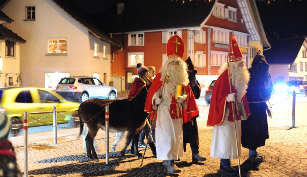 Wie in eine fremde Zeit geraten: Samichlaus und Schmutzli mit Eseli im dichten Verkehr auf der Hauptstrasse durch Marbach.