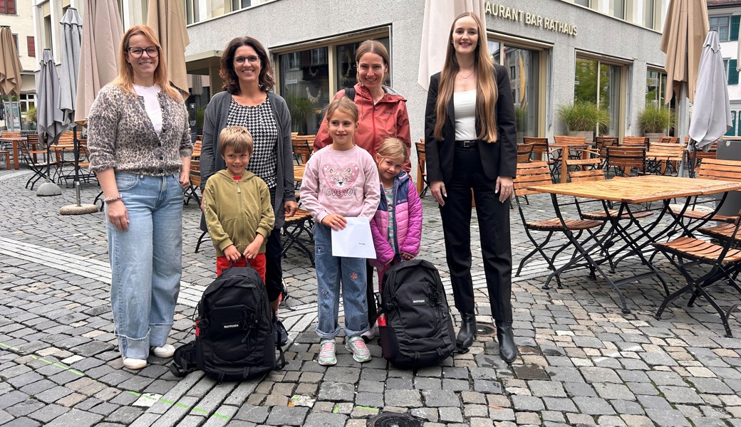 Prall gefüllte Rucksäcke für kluge Köpfe: Mirjam Seitz, Stadträtin, Ruben Hutter mit seinem Mami, die Schwester und das Mami von Pia Hahn sowie Ivana Skaro von der Raiffeisenbank Oberes Rheintal bei der Preisübergabe (v.l.n.r.).