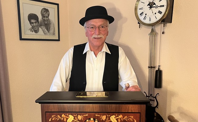 Der Mann an der Drehorgel umarmt Menschen mit Musik