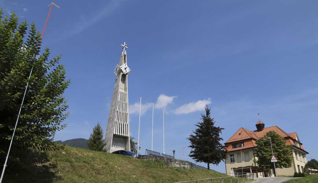 Der Pfarreiheim Neubau ist direkt neben der Kirche geplant, dort, wo jetzt Wiesenbord, drei Fahnenstangen und die Sitzbänke zu sehen sind.  