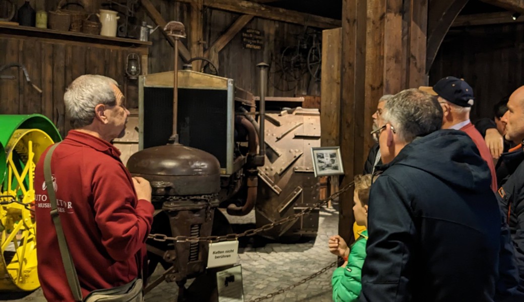 TCS-Mitglieder folgen den Erklärungen des Guides an der Führung durchs Auto- und Traktormuseum.
