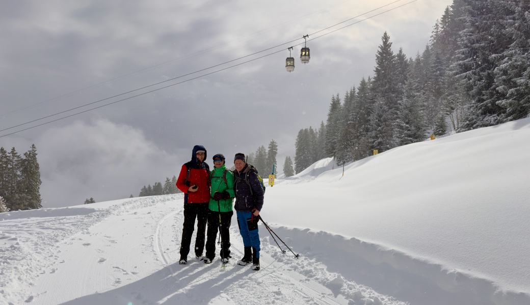 Fröhliche Wandergruppe mit Schneefall und Sonnenschein